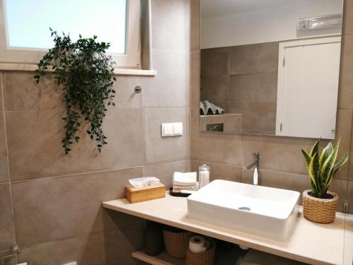 a bathroom with a sink and a mirror at OCEAN TERRACES by VILA GAIVOTA D in Ferragudo