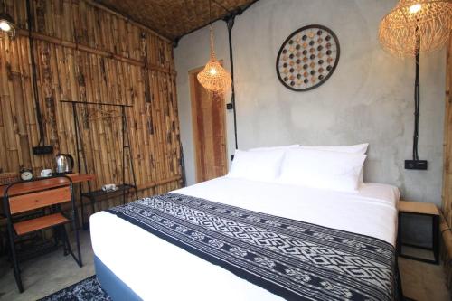 a bedroom with a bed and a desk and chandeliers at Sawah Ijen in Licin
