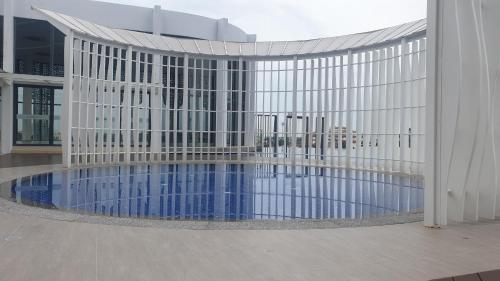 a building with a swimming pool in front of a building at Prestige Troika Luxury Stay in Kota Bharu