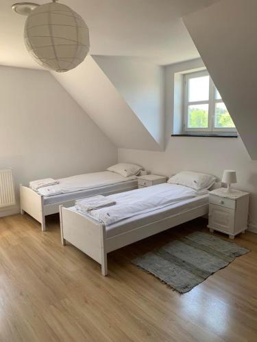 a bedroom with two beds and a window at Osada Rydzewo in Rydzewo