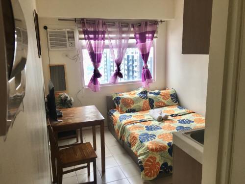a small living room with a couch and a window at Booker Com in Mandaluyong in Manila