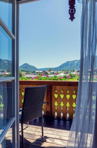 a chair on a balcony with a view of the mountains at Haus Sonja in Altaussee