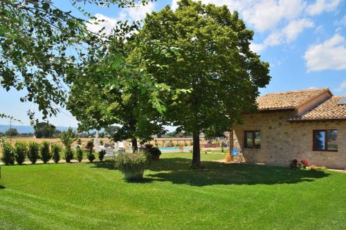 a house with a yard with a tree in the yard at Antiche Dimore San Felice in Spello