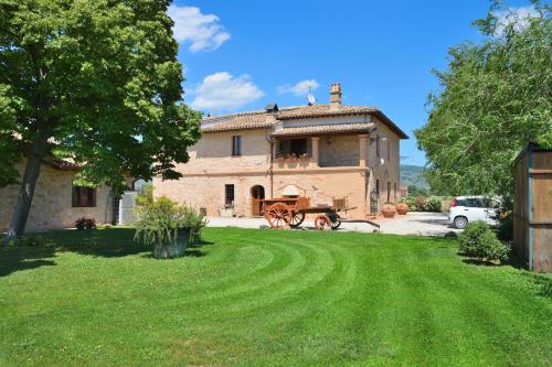 a house with a horse and carriage in a yard at Antiche Dimore San Felice in Spello