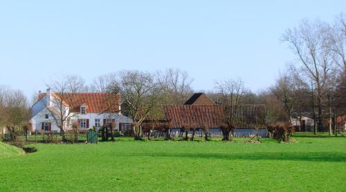 a house with a green field in front of it at B&B Hullebrug in Heist-op-den-Berg