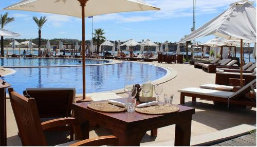 a table and chairs next to a swimming pool at OCEAN TERRACES by VILA GAIVOTA D in Ferragudo