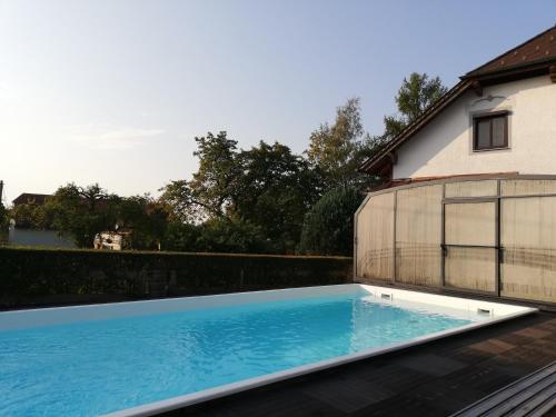 ein großer Pool neben einem Haus in der Unterkunft Kinderbauernhof Wachmann in Rohrbach am Kulm