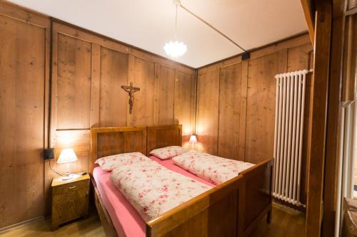 ein Schlafzimmer mit einem Bett in einer Holzwand in der Unterkunft Casa Sartori in Tesero