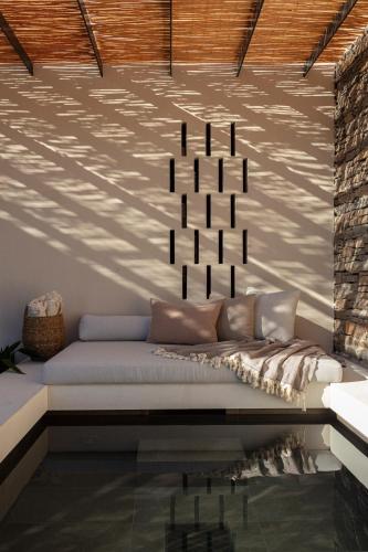 a living room with a couch in front of a wall at NOS Hotel & Villas in Sifnos
