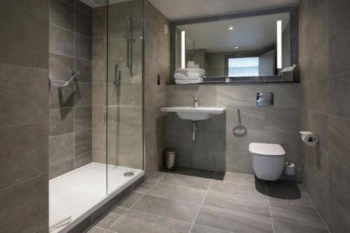 a bathroom with a shower and a sink and a toilet at Maldron Hotel Parnell Square in Dublin