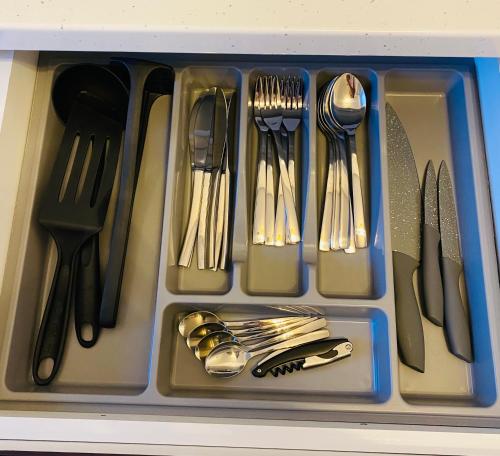 a plastic tray filled with utensils in a drawer at Dina Lux Iasi Apartment in Iaşi