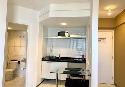 a small kitchen with a table and a microwave at Biarritz temporadalitoranea in São Luís