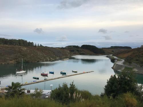 a river with boats on a dock in the water at Appartement T3 vue mer Sauzon balcon et parking privé in Sauzon