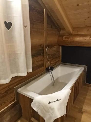 La salle de bains en bois est pourvue d'un lavabo blanc et d'une serviette. dans l'établissement Chalet Sempre Més, à Font-Romeu-Odeillo-Via