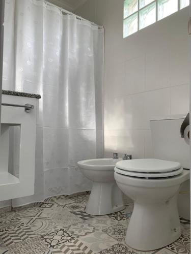 a white bathroom with a toilet and a shower at Aloha in Colón