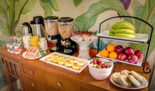 een houten tafel met daarop veel eten en fruit bij Auld Sweet Olive Bed and Breakfast in New Orleans