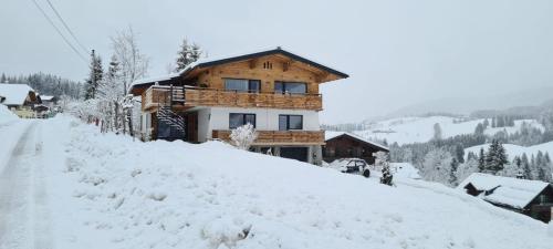 a house on top of a snow covered hill at Alpenhaus Donnerkogel in Annaberg im Lammertal