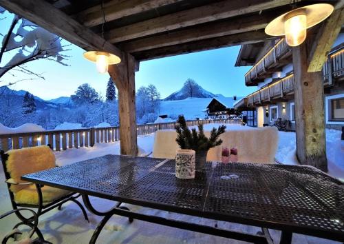 a table and chairs on a patio with snow at Der Trueferhof in Ehrwald