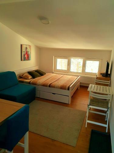 a bedroom with a large bed and a blue couch at Divcibare Centar 2 in Divčibare
