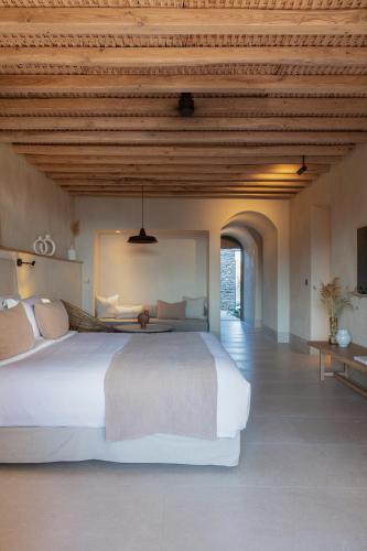 a bedroom with a large bed with a wooden ceiling at NOS Hotel & Villas in Sifnos