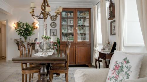 a dining room with a table and a chandelier at Casa Do Adro Da Igreja Turismo De Habitação in Vila Nova de Milfontes