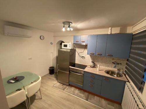 a kitchen with a refrigerator and a table in it at Apartman Abramović in Topusko