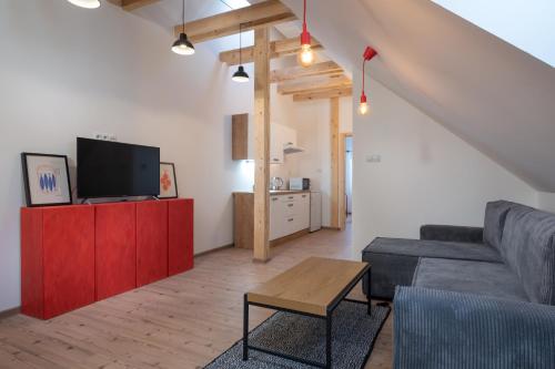 a living room with a couch and a tv at Apartmány Ski Telgárt in Telgárt