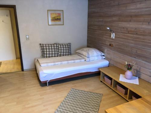 um pequeno quarto com uma cama e uma mesa em Haus Meinrad em Seefeld no Tirol