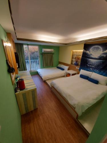 a hotel room with two beds and a window at 韖旅店-民宿編號1158 in Kenting