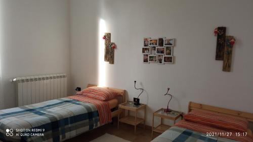 una camera con due letti e un tavolo con una lampada di Etna, salvia e rosmarino a Maletto