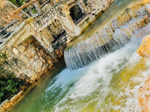 an aerial view of a waterfall in a river at Altos de Caño Hondo in Los Guineos Perdidos