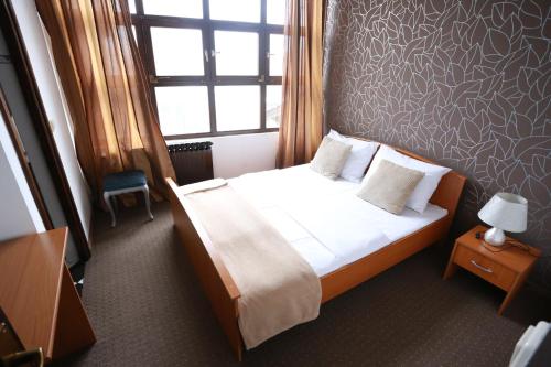 a bedroom with a large bed with a window and a bed sidx sidx at Rustika Sobe in Osijek