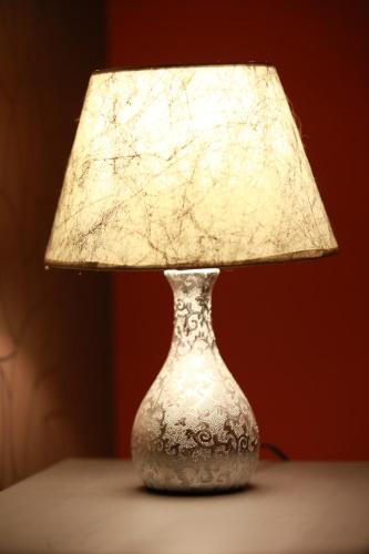 a silver vase with a lamp on a table at Rustika Sobe in Osijek