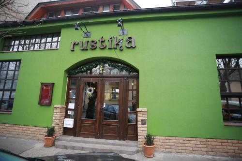 a green building with a entrance to a restaurant at Rustika Sobe in Osijek