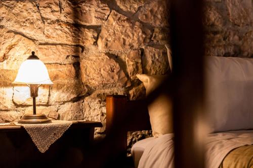 a bedroom with a bed and a lamp on a table at Guesthouse Armakas in Kalavrita