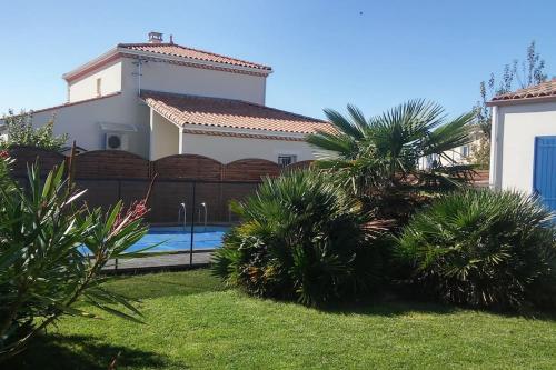 een huis met een hek en een zwembad bij Maison familiale avec piscine chauffée in Saint-Georges-de-Didonne