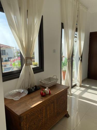 a room with a wooden table in a room with windows at Two bedroom Duplex :Mountain and Sea view in Larnaca