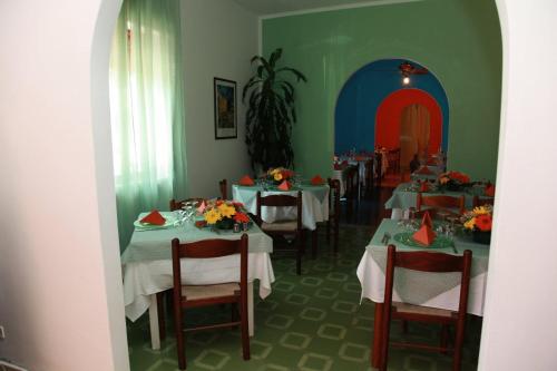 uma sala de jantar com mesas com flores em Luigiane B&B em Acquappesa