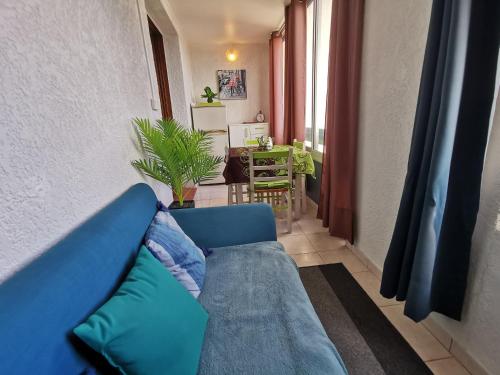 un canapé bleu dans un salon avec une table dans l'établissement Appartement Marina Soleil Bleu, au Barcarès