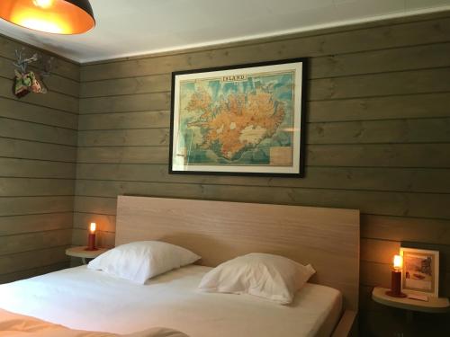 - une chambre avec un lit et une photo sur le mur dans l'établissement Le Voyageur, à Mürringen