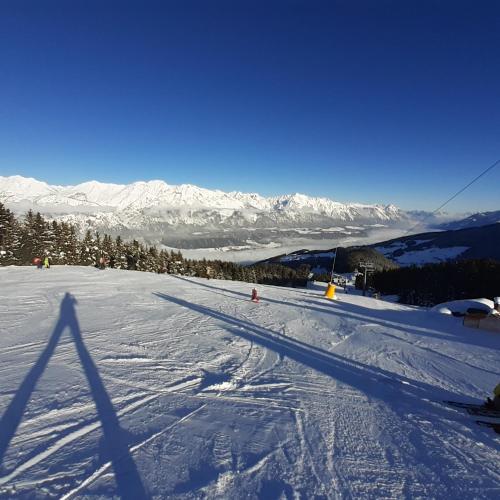 a snow covered slope with people skiing on a mountain at Apart Grubertal in Volders