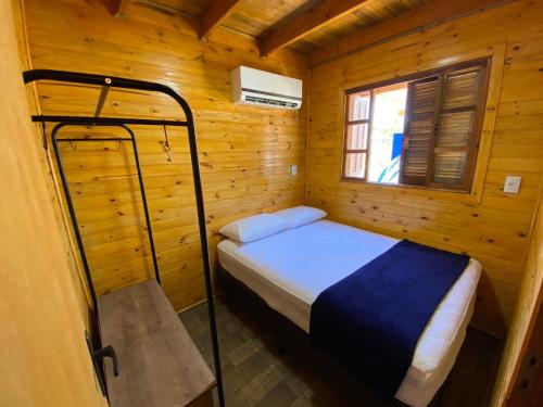 パリョサにあるCabana do Embaú Experienceの木造キャビン内のベッド1台が備わるベッドルーム1室を利用します。