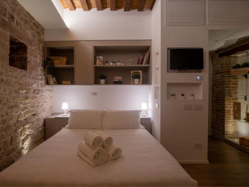 een slaapkamer met een bed met handdoeken erop bij Residenza Donna Iohanna in Gubbio