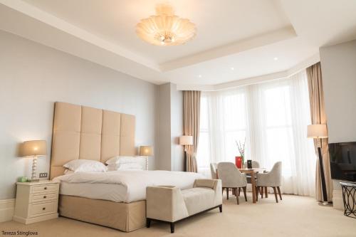 1 dormitorio con cama, silla y escritorio en The Chatsworth Hotel, en Eastbourne