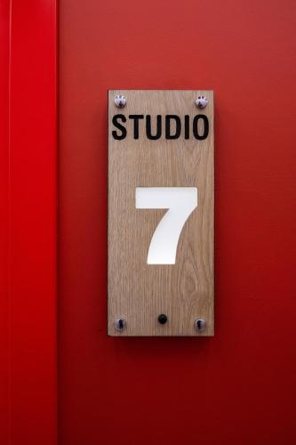 a wooden sign with the on a red wall at Spa & Pool - Studio Apartments 365 in Tirana