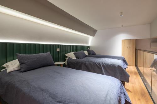 two beds in a room with green walls at Spa & Pool - Studio Apartments 365 in Tirana