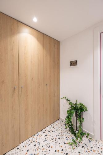 a room with a large wooden closet with a plant on the floor at Spa & Pool - Studio Apartments 365 in Tirana