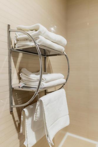 a towel rack in a bathroom with white towels at СПА Готель СВ in Khmelnytskyi