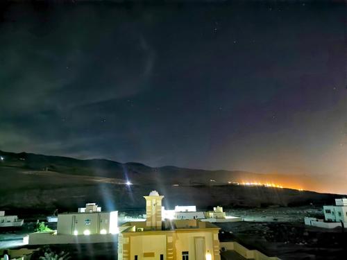 a view of a city at night at 228Hostel in Al Ḩamrāʼ