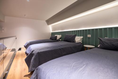 two beds in a room with green walls at Spa & Pool - Studio Apartments 365 in Tirana